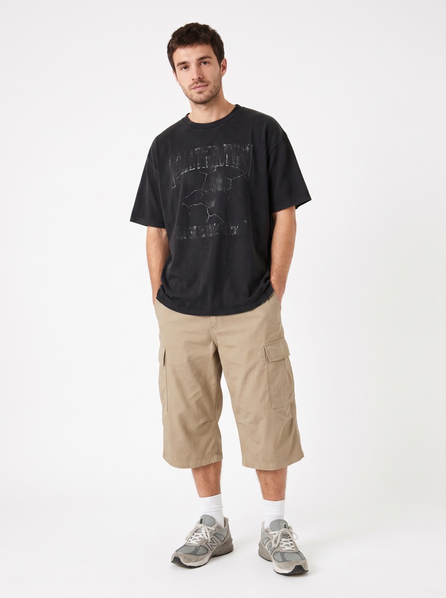 A man in a faded band tee and cargo shorts
